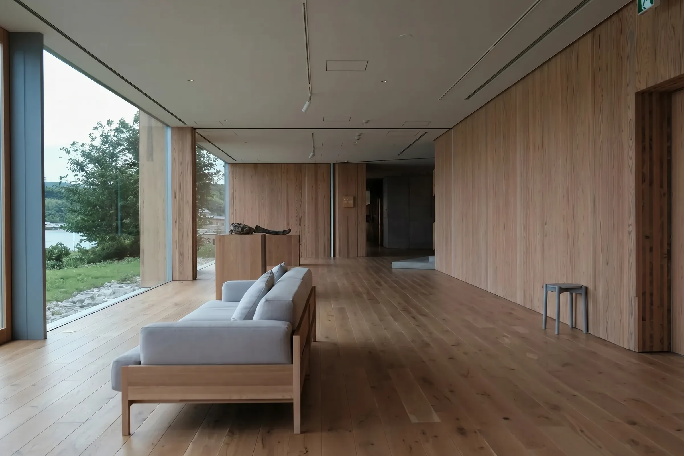Renovierter Raum in minimalem Holzstil mit Couch und Fenster